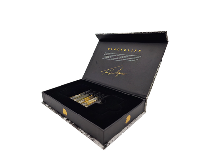 Five mini fragrance bottles in open black gift box, angled view