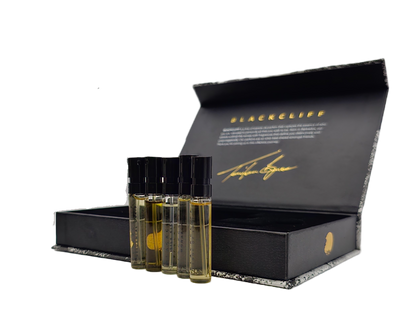 Mini fragrance bottles beside open black box with gold logo